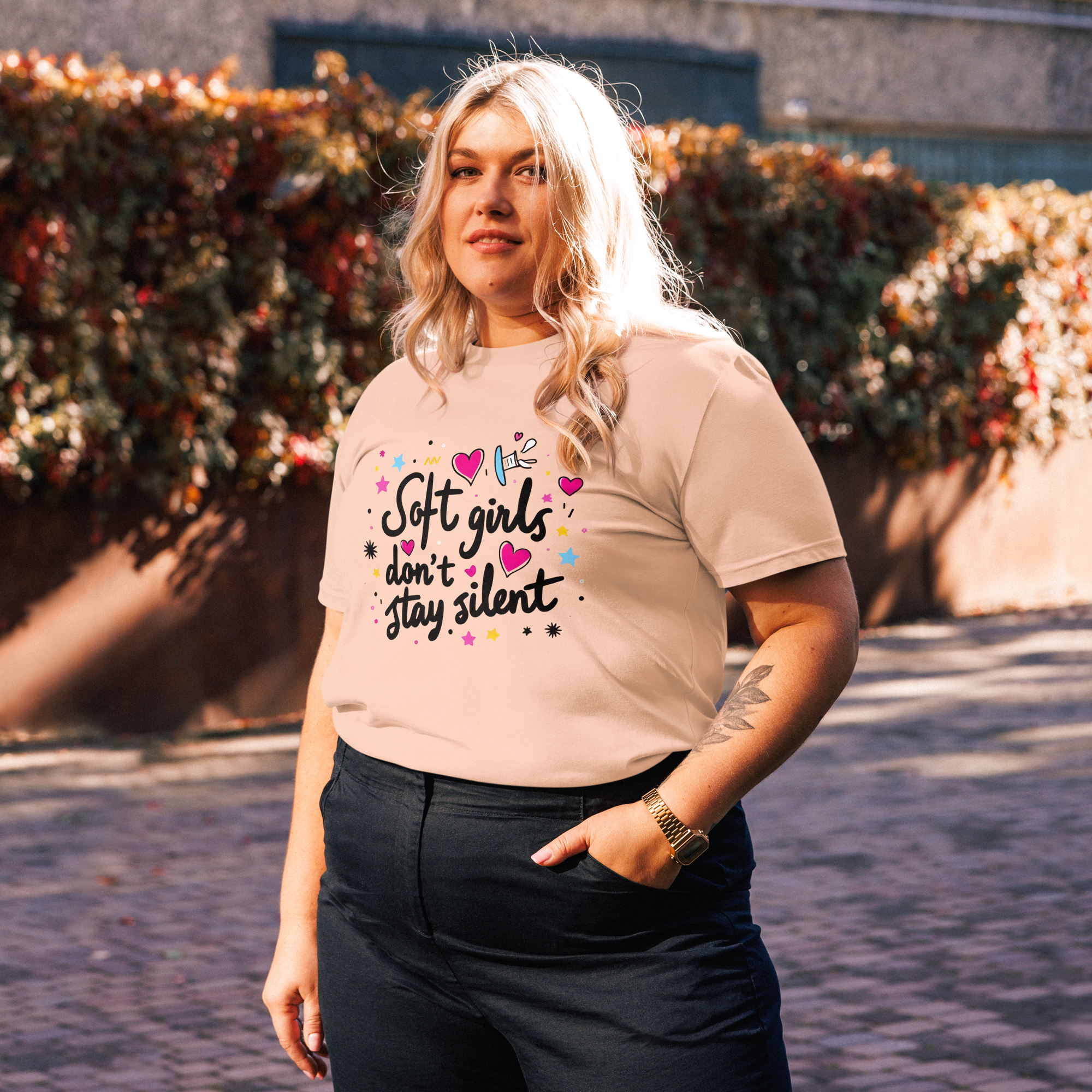 Person wearing a beige t-shirt with colorful text outdoors